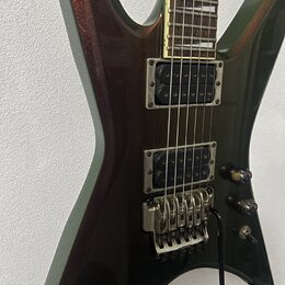 Elektrická kytara s tmavě hnědým kovovými lakem a hranatým tvarem těla. Nástroj má dva humbuckery, tremolo systém a dvě ovládací knoflíky. Na těle ne…
