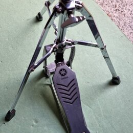 Chromovaný stojan s pedálem, který má na horní části nápis YAMAHA a doprovodné logo. Na spodní části pedálu je viditelný nápis PROFESSIONAL MODEL. Po…