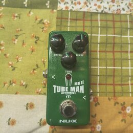 Zelený kytarový efekt pedál s nápisy DRIVE, LEVEL a TONE u ovládacích knoflíků. Uprostřed je bílý nápis TUBE MAN MK II OVERDRIVE s ikonou vakuumové t…