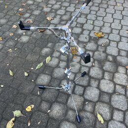 Kromový stojan na nástroje s třemi rameny zakončenými černými gumovými chrániči. Stojan má nastavitelné výškové a šířkové mechanismy s kovovými šroub…