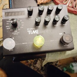 Černý kytarový efekt s nápisem strymon TIMEline. Na horní straně se nachází pět ovládacích knoflíků s popisky VALUE, TIME, REPEATS, MIX, FILTER, GRIT…