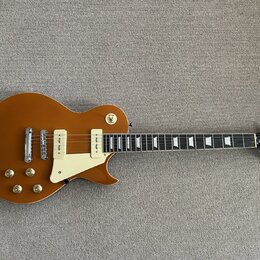 Hnědá elektrická kytara s tvarem singlecut a bílým plechtrzem. Na hlavě je viditelné logo „Epiphone“. Nástroj má dva humbuckery s bílými rámečky a čt…