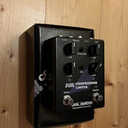Černý kytarový pedál s nápisem DUAL COMPRESSOR LIMITER a značkou CARL MARTIN Designed In Denmark. Zařízení má čtyři otočné oválné knoflíky s popisky…