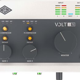 Audio rozhraní s bílým šasi a dřevěnými bočními panely. Na čelní straně je tmavý panel s nápisy VOLT 2 76, UA a ovládacími prvky Gain 1, Gain 2 a Mon…