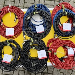Šest svátků audio kabelů v červené, modré a černé barvě s XLR konektory. Na kabelech jsou bílé cenovky s nápisy: „13 m 400,-“, „11 m 350,-“, „8 m 300…