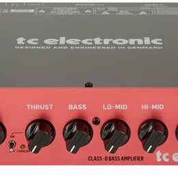 Červený basový zesilovač s šedým horním krytem. Na předním panelu jsou nápisy THRUST BQ500, INPUT a ovládací knofíky GAIN, THRUST, BASS, LO-MID, HI-M…
