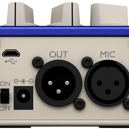 Zadní strana modrého zařízení s krémovým panelem. Jsou zde vidět konektory USB, XLR označený jako OUT a XLR označený jako MIC, dále vypínač s nápisy…