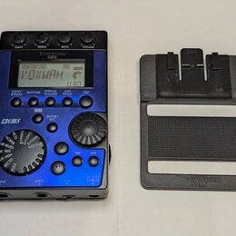 Modrý kytarový efekt s displejem, na kterém je nápis VOXWAH. Na horní části je značka ToneWorks a model X-Bass, vlevo nápis BEMS. Zařízení obsahuje n…
