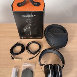 Na fotografii je sada sluchátek s příslušenstvím. Je zde černý papírový box s oranžovým vrchem a nápisy CROSSFADE LP2, milano design a vmoda. Součást…