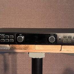 Černý rackový audio rozhraní s nápisem APOGEE a logem vlevo a názvem ensemble Thunderbolt Audio Interface vpravo. Přední panel obsahuje několik vstup…