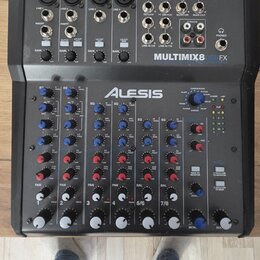 Černý mixovací pult s nápisem MULTIMIX8 USB FX a logem ALESIS. Zařízení obsahuje čtyři mikrofonní vstupy, linkové vstupy, různé ovládací prvky v podo…