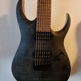 Elektrická kytara s tmavě šedým tělem s viditelnou strukturou dřeva a hnědým hmatníkem. Nástroj má dva černé humbuckery, jeden ovládací knoflík a pře…