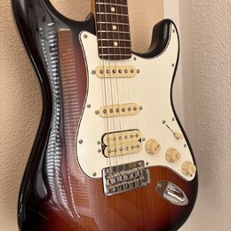 Elektrická kytara s telyem v provedení sunburst a bílým pickguardem. Nástroj má tři snímače s bílými kryty, tři otočné knofíky a jeden přepínač. Povr…