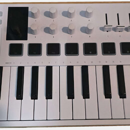Bílá MIDI klaviatura s názvy MINILAB 3 a ARTURIA. Horní panel obsahuje osm bílých otočných knoflíků, čtyři posuvníky a řadu ovládacích tlačítek s náp…