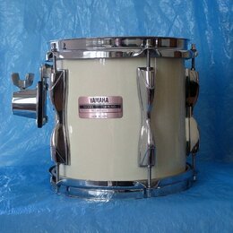 Bílý buben s chromovaným kováním a obručemi. Na korpusu je nalepený štítek s nápisy YAMAHA, MODEL RECORDING a MADE IN JAPAN. Povrch nástroje i kování…