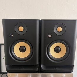 Dva černé studiové monitory značky KRK SYSTEMS. Oba mají žlutý basový reproduktor a menší výškovek v horní části. V dolní části je u obou zařízení ná…