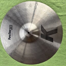 Kruhový činel v kovovém provedení s viditelným broušením povrchu. Na ploše je černý nápis PAPER THIN CRASH a velikost 18" / 46 cm, vpravo velké logo…