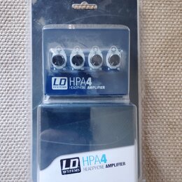 Modrý sluchátkový zesilovač v originálním plastovém balení. Na přístroji i na krabici je bílý nápis LD SYSTEMS HPA4 HEADPHONE AMPLIFIER. Zařízení má…