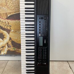 Černý digitální klavír s bílými a černými klávesami. Na ovládacím panelu je viditelné logo YAMAHA a řada tlačítek a posuvníků. Nástroj je umístěn svi…