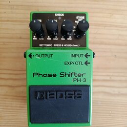 Zelený kytarový efekt s černým spínacím pedálem. Na šasi jsou nápisy Phase Shifter, PH-3 a logo BOSS. Horní panel obsahuje čtyři černé otočné ovladač…