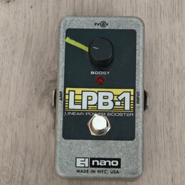 Kytarový efekt v šedém kovovém šasi s černým ovládacím panelem. Na panelu je jeden otočný knoflík, červená kontrolka a nápisy LPB-1 LINEAR POWER BOOS…