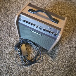 Kompaktní kytarový zesilovač s hnědým textilním potahem a černým předním panelem. Na horní hraně je nápis LOUDBOX MINI CHARGE a na mřížce logo FISHMA…