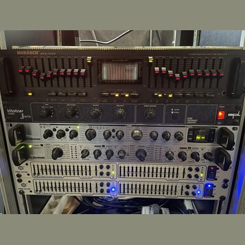 Sestava rackového audio vybavení v černém a stříbrném provedení. Horní jednotka nese nápisy MONARCH SAE-1000 a 10 BAND EQUALIZER/REAL TIME ANALYZER s…