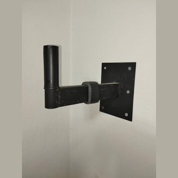 Černý nástěnný držák na hudební nástroj vyrobený z kovových trubek a ploché základny. Horní část je potažena černým materiálem, podobně jako opora v…