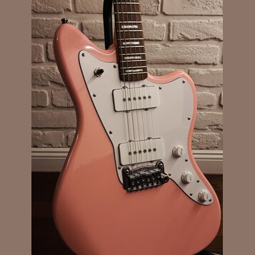Růžová elektrická kytara s bílým pickguardem a dvěma bílými snímači typu single-coil. Nástroj má hnědý hmatník a stříbrný most s saddles. Na bílých o…