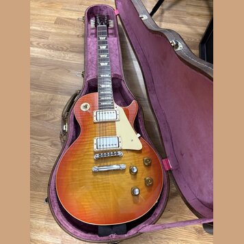Elektrická kytara s trupem ve tvaru Les Paul v barevné variantě sunburst s viditnou strukturou dřeva. Nástroj má dva humbuckery, krémový pickguard a…
