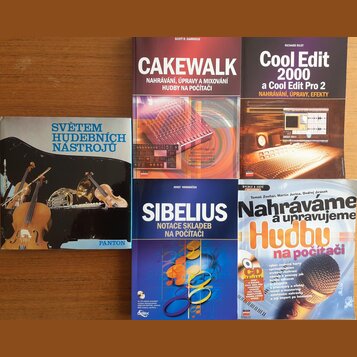 Fotografie zobrazuje čtyři knihy a jednu CD obálku položenou na dřevěném stole. Viditelné jsou názvy: „SVĚTEM HUDEBNÍCH NÁSTROJŮ“ s logem PANTON, „CA…
