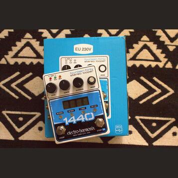Bílý efekt pedál s nápisy fourteen-forty stereo looper a electro-harmonix NEW YORK CITY, USA. Na spodní části je výrazné modré číslo 1440 a několik o…