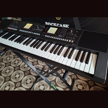 Černý digitální klavír umístěný na černém stojanu s nápisem STIM. Na ovládacím panelu je viditelné logo Roland a nápis XPS-10. Nástroj má bílé a čern…