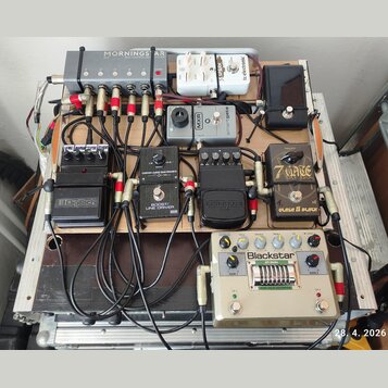 Fotografie zachycuje efektový pedalboard v hliníkovém kufru. Na desce je umístěno několik pedálů s nápisy MORNINGSTAR MIDI CONTROLLED SWITCHER, tc el…