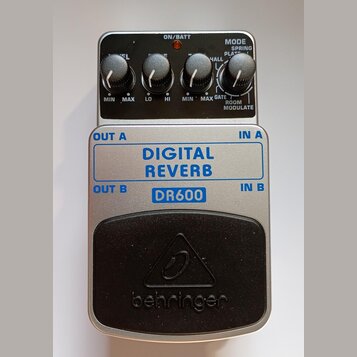 Stříbrný efekt pedál s nápisy DIGITAL REVERB a DR600. V horní části jsou čtyři ovládací knoflíky, přepínač MODE s variantami SPRING, PLATE, HALL, ROO…