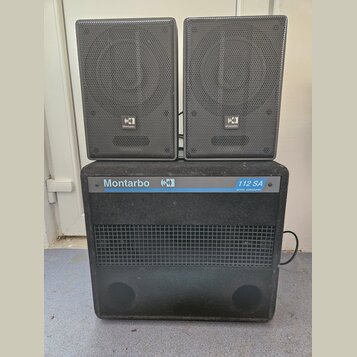 Sada tří černých reproduktorů, která obsahuje dva menší horní reproduktory a jeden velký spodní subwoofer. Na všech třech je viditelné logo s nápisem…