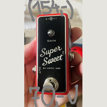 Červený kytarový efekt s černým čelním panelem. Na panelu je nápis GAIN, velký bílý nápis Super Sweet N a text BY xotic usa. V horní části je označen…