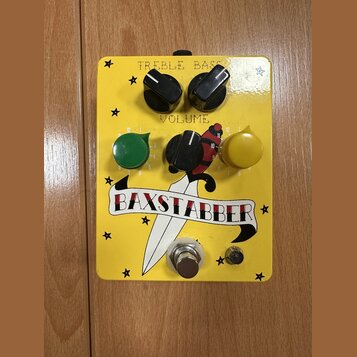 Žlutý kytarový efekt s pěti ovládacími knoflíky a jedním zapínacím spínačem. Na horní části jsou nápisy TREBLE, BASS a VOLUME. Uprostřed je umístěn g…
