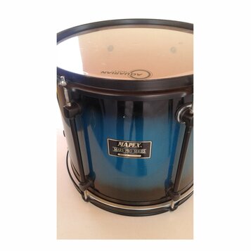 Modrý buben s přechodem do černé barvy. Na koruse je nápis AQUARIAN FOCUS-X. Na korpusu se nachází štítek s textem MAPEX PERCUSSION TECHNOLOGY MARS P…