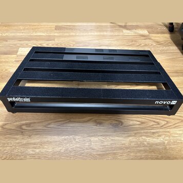 Černý kovový pedalboard s mřížkovou konstrukcí a protiskluzovými gumovými pásky. Na přední hraně je bílý nápis pedaltrain a v pravém dolním rohu ozna…