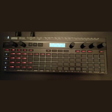 Černý sekvencer s nápisem KORG SQ-64 POLY SEQUENCER. Zařízení obsahuje mřížku šestiřadých šedých tlačítek, z nichž několik v levé části svítí červeně…