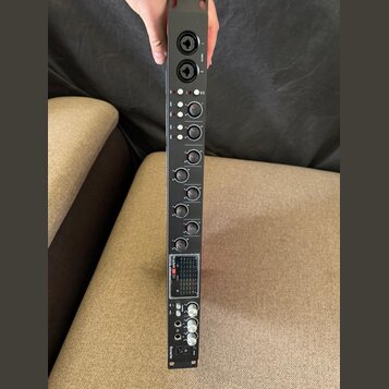 Černý rackový procesor s řadou otočných ovladačů a několika červenými kontrolkami. V dolní části je digitální displej s nápisem Soundcraft UC a pod n…