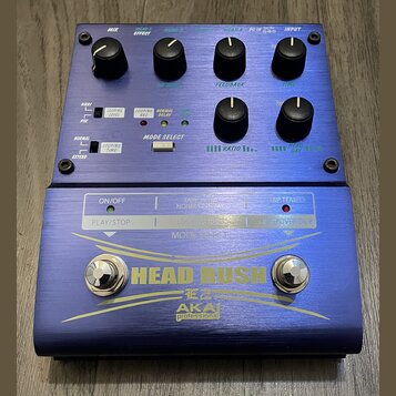 Modře anodizovaný efekt pedál s nápisem HEAD RUSH a logem AKAI professional. Horní panel obsahuje čtyři ovládací knoflíky v horní řadě a dva v dolní,…