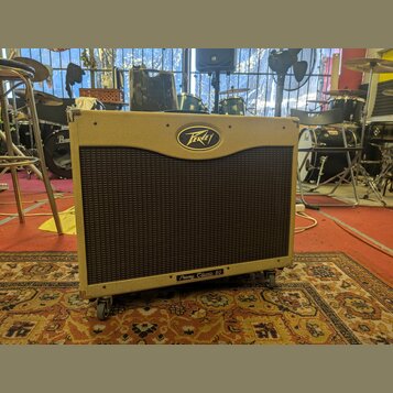 Kytarový kombo zesilovač v béžovém potahu s texturou. Na horní části je oválné logo Peavey a v dolní části nápis Peavey Classic 50. Přední strana je…
