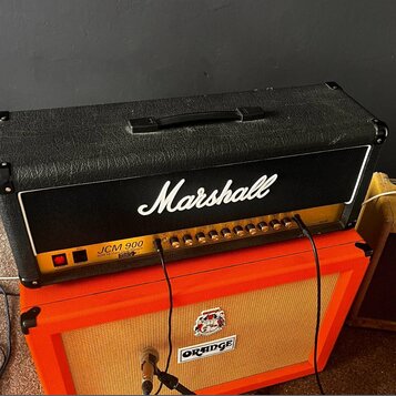 Černý kytarový kombozesilovač značky Marshall s bílým nápisem Marshall a označením JCM 900 50W HC Lead Dual Reverb. Přední panel obsahuje řadu ovláda…
