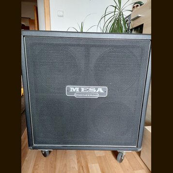 Černý kytarový reproduktor v kostce potažený vinylen s černou textilní maskou. Uprostřed je umístěn stříbrný oválný štítek s nápisem MESA ENGINEERING…