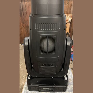 Černý svítící přístroj s matným povrchem a ventilačními mřížkami. Na spodní části korpusu je bílý nápis ROBE. Zařízení vykazuje mírné opotřebení a pr…