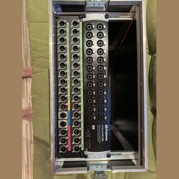 Digitální mixážní konzole PreSonus StudioLive 32R osazená v hliníkovém transportním case. Zařízení má černý povrch s řadou vstupů a výstupů typu XLR…