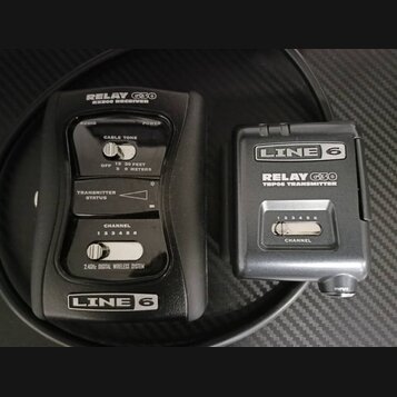 Černý bezdrátový systém Line 6 Relay G30 složený z přijímače a vysílače. Na přijímači jsou nápisy RELAY G30 RX500 RECEIVER, AUDIO, POWER, CABLE TONE,…