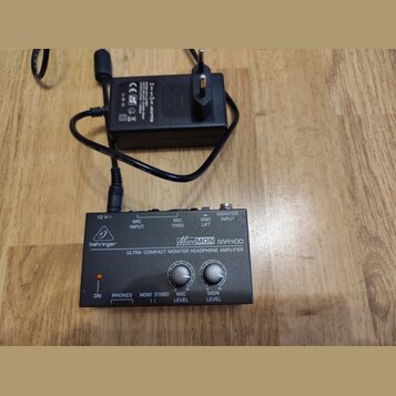Černý kompaktní sluchátkový zesilovač s nápisem behringer a modelem MicroMON MA400 ULTRA-COMPACT MONITOR HEADPHONE AMPLIFIER. Zařízení má v horní čás…